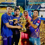 IPL स्टेडियम में KKR टीम के खिलाड़ी अपने परिवार के साथ ट्रॉफी पकड़े हुए, चारों ओर गोल्डन कंफेटी और जश्न का माहौल|