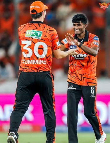 Two Sunrisers Hyderabad cricket players celebrating on the field, with one player wearing jersey number 30 (Cummins) and the other smiling and clapping during a match